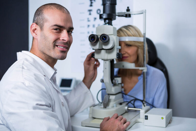 Portrait,Of,Smiling,Optometrist,Examining,Female,Patient,On,Slit,Lamp