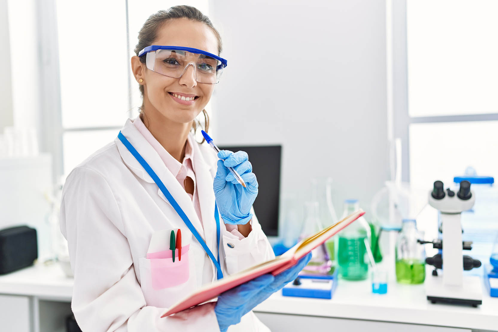 Young,Hispanic,Woman,Wearing,Scientist,Uniform,Writing,On,Notebook,At