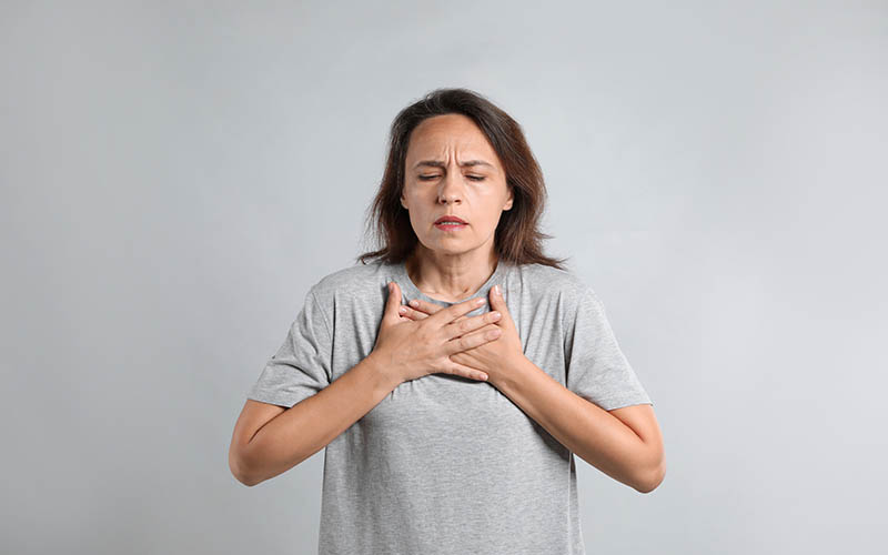 Mature,Woman,Suffering,From,Breathing,Problem,On,Light,Background