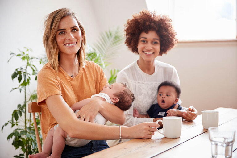 Portrait,Of,Two,Mothers,With,Babies,Meeting,Around,Table,On